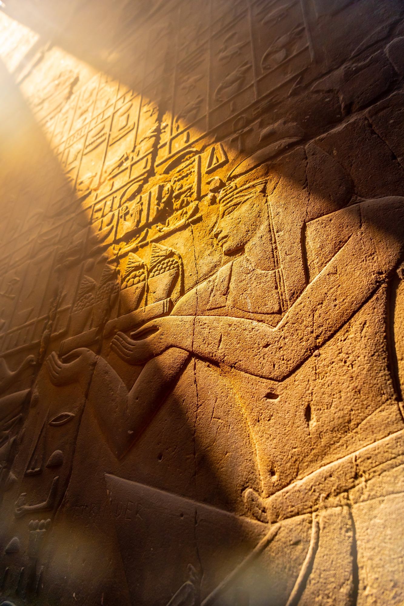 Carved reliefs on a temple wall in bright sunlight